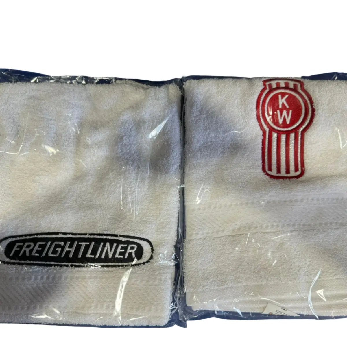 Two white towels with 'FREIGHTLINER' text and a red and gray logo on the bottom, packaged in clear plastic.