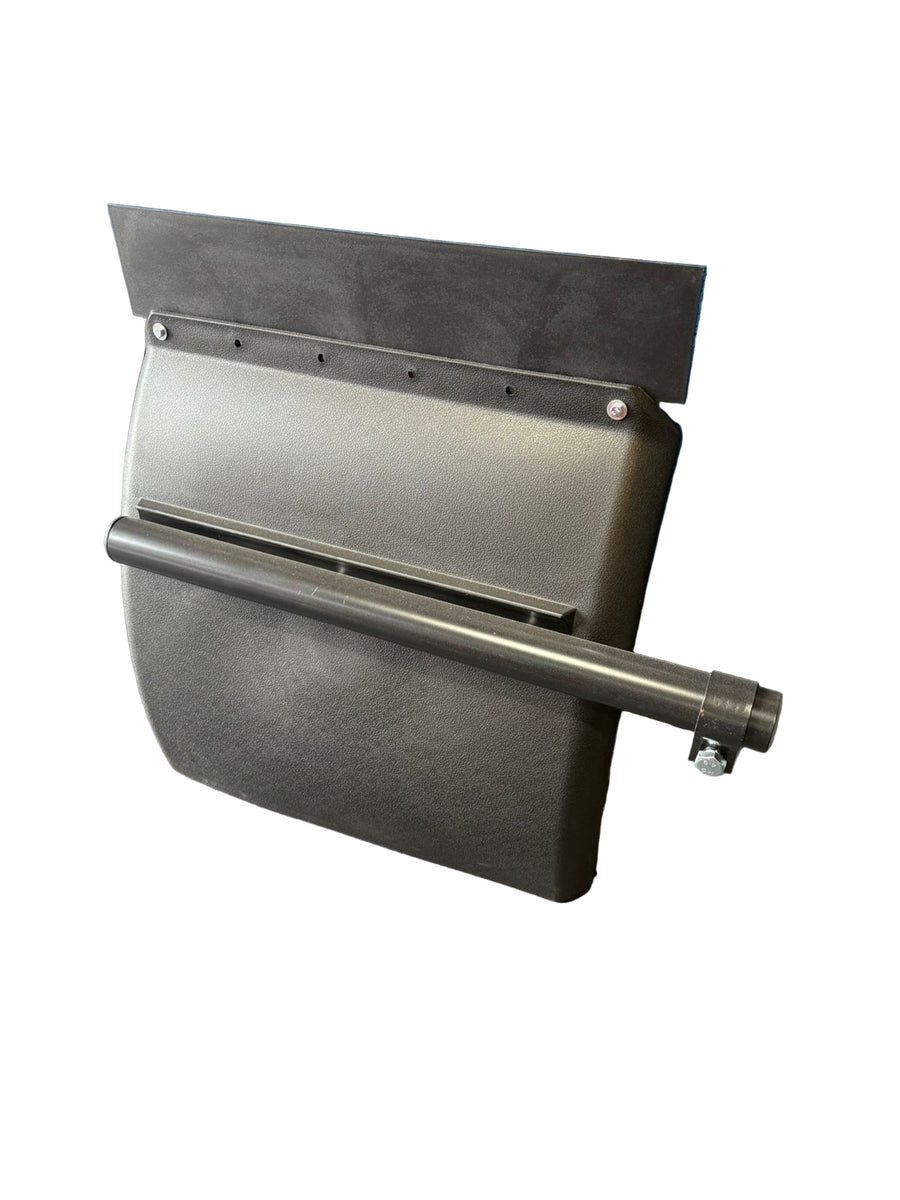 Black metal bracket or component on a gray surface with a blue wall and shelves in the background.